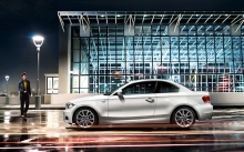 Белый BMW 1 серии Coupe напротив стеклянного ангара